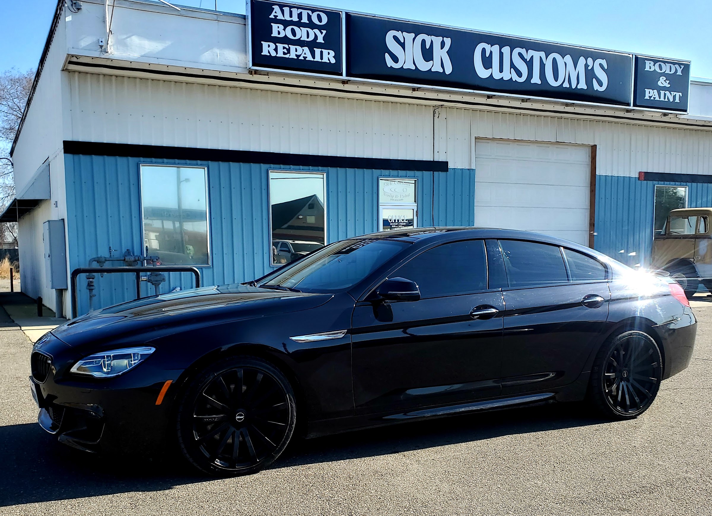 A black BMW 6 Series with blacked-out wheels detailed at Sick Custom Collision